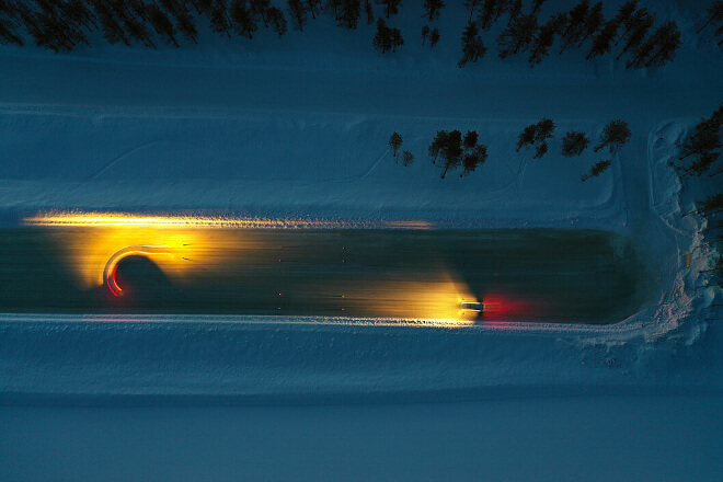 Two cars in motion on ice, bird's-eye view.